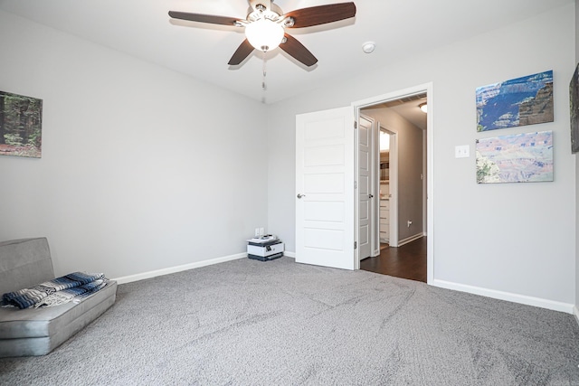 spare room featuring ceiling fan and dark carpet