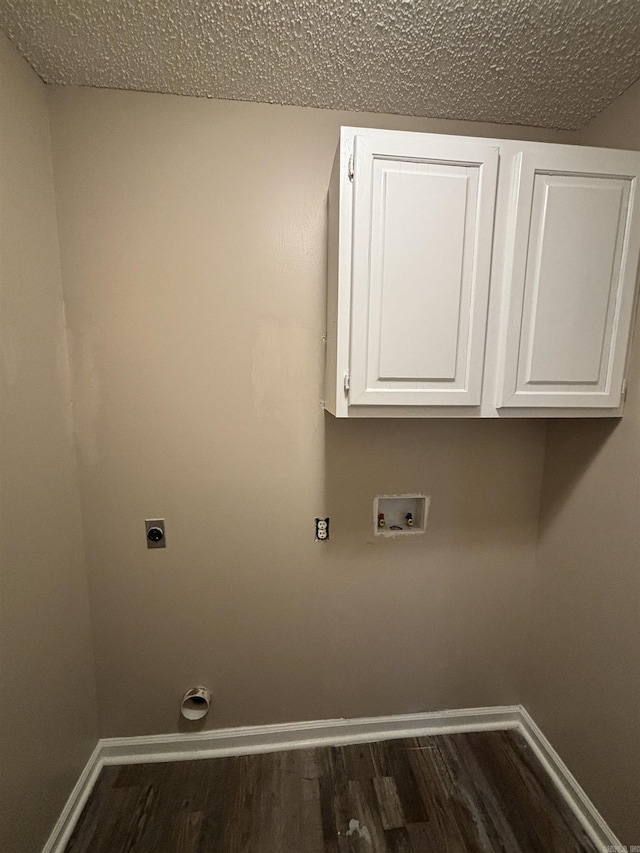 laundry room with cabinets, hookup for a washing machine, a textured ceiling, electric dryer hookup, and dark hardwood / wood-style floors