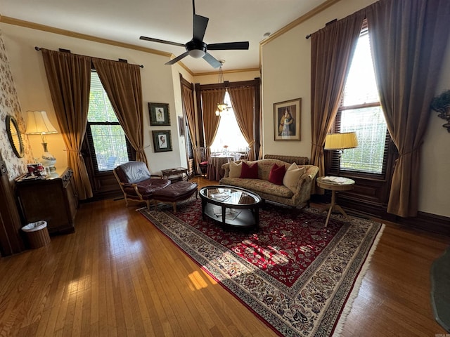 living room featuring dark hardwood / wood-style floors, ceiling fan, and crown molding