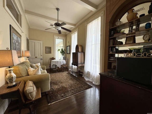 living area with beam ceiling, dark hardwood / wood-style flooring, and ceiling fan