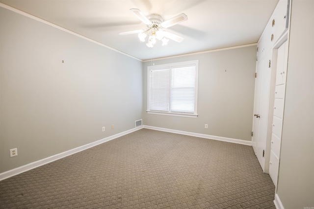 unfurnished bedroom with ornamental molding, carpet, and ceiling fan