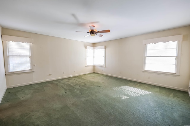 empty room featuring ceiling fan and dark colored carpet