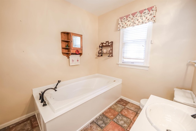 bathroom with a washtub, sink, and toilet