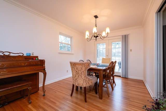 dining area featuring light hardwood / wood-style flooring, a notable chandelier, and ornamental molding