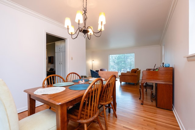 dining space with a chandelier, light hardwood / wood-style flooring, and crown molding