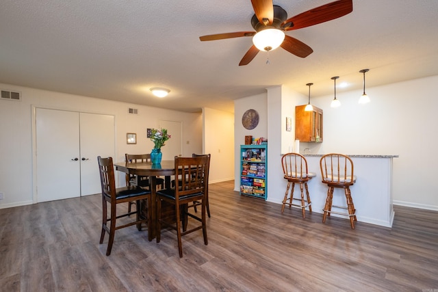 dining area featuring a textured ceiling, dark hardwood / wood-style floors, and ceiling fan