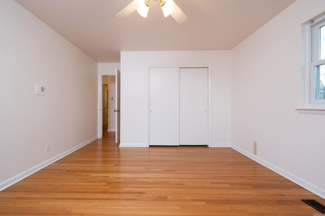 unfurnished bedroom featuring ceiling fan, a closet, and light hardwood / wood-style flooring