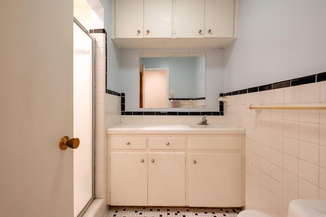 bathroom with tile patterned floors, vanity, and tile walls