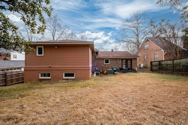 rear view of house with a yard and cooling unit