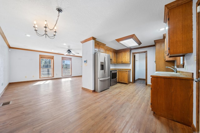 kitchen with ornamental molding, ceiling fan with notable chandelier, stainless steel appliances, pendant lighting, and light hardwood / wood-style flooring