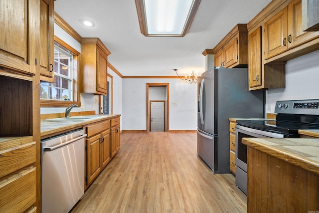 kitchen with sink, stainless steel appliances, a notable chandelier, crown molding, and light hardwood / wood-style floors