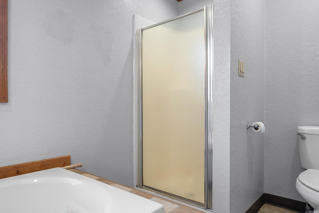 bathroom with a shower with shower door and toilet