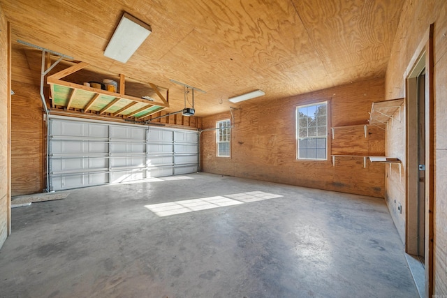 garage with a garage door opener and wood walls