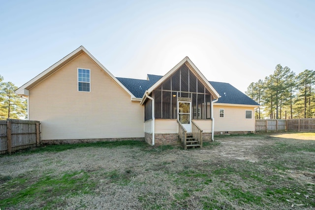 rear view of property with a sunroom and a yard