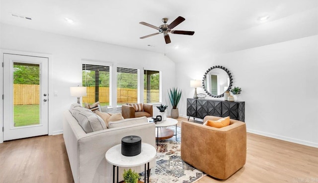 living room featuring a wealth of natural light, ceiling fan, lofted ceiling, and light wood-type flooring