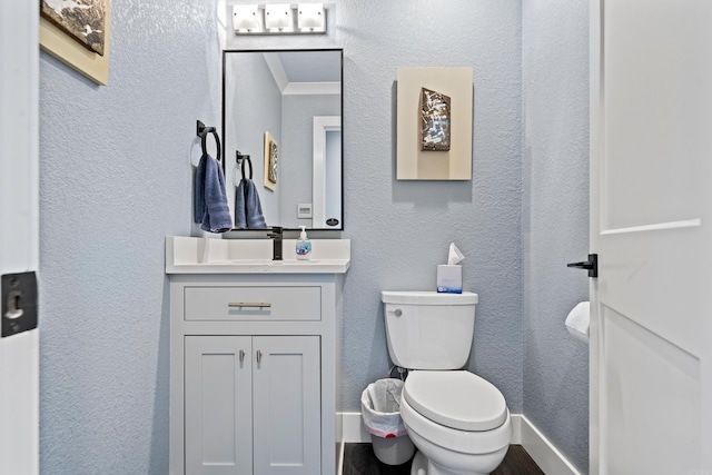 bathroom featuring crown molding, vanity, and toilet