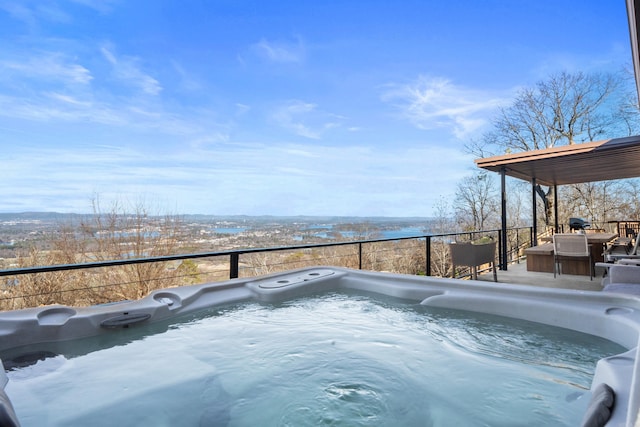 view of swimming pool with a water view and a hot tub