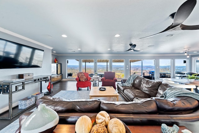 living room featuring ceiling fan, ornamental molding, and dark wood-type flooring