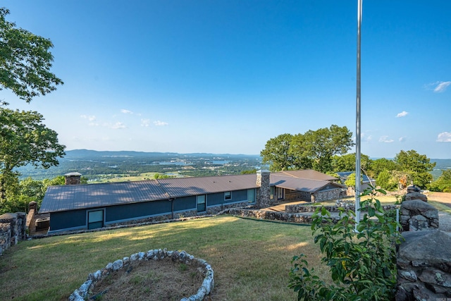 rear view of property with a mountain view and a yard