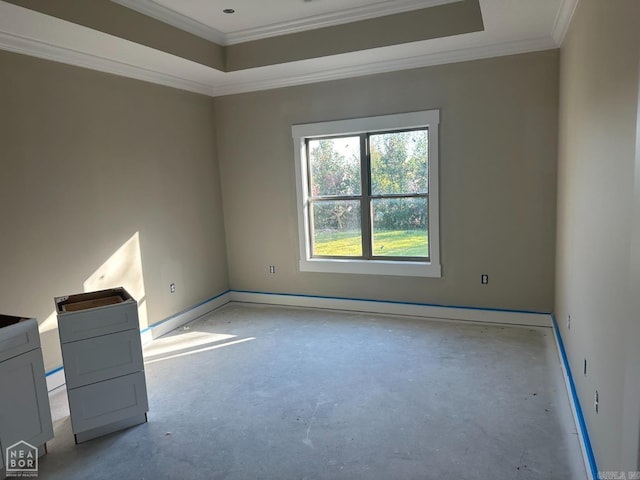 empty room with a raised ceiling and crown molding