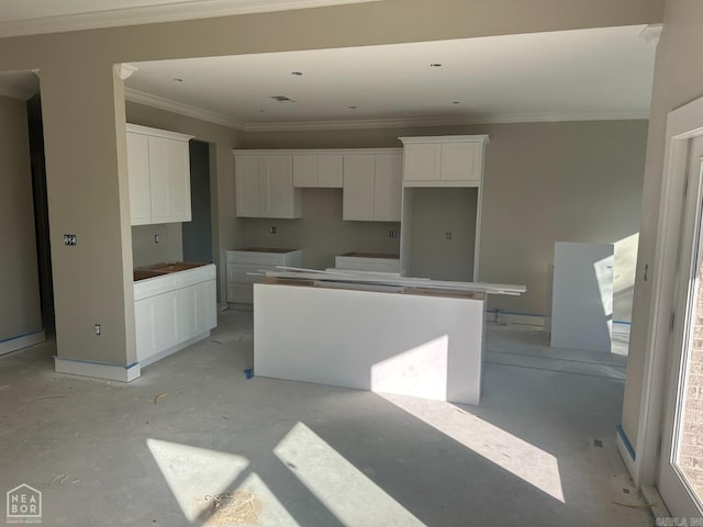 kitchen featuring crown molding, a center island, and white cabinets