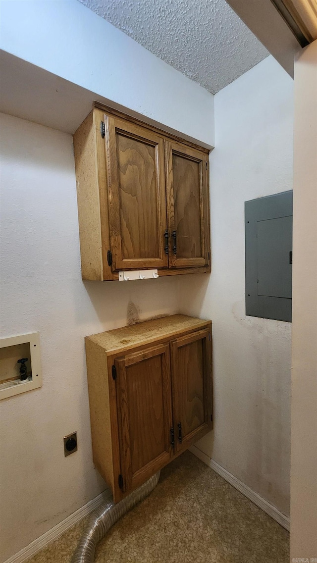 interior space featuring cabinets, electric dryer hookup, electric panel, hookup for a washing machine, and a textured ceiling