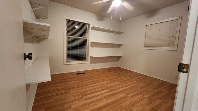 spacious closet with light hardwood / wood-style flooring and ceiling fan