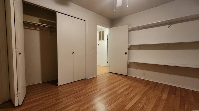 unfurnished bedroom with ceiling fan, a closet, and light wood-type flooring