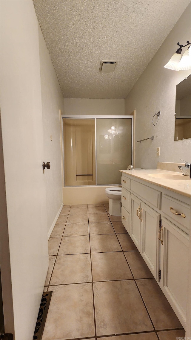 full bathroom with vanity, shower / bath combination with glass door, tile patterned flooring, toilet, and a textured ceiling