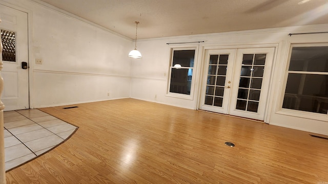 spare room featuring french doors, light hardwood / wood-style flooring, and crown molding