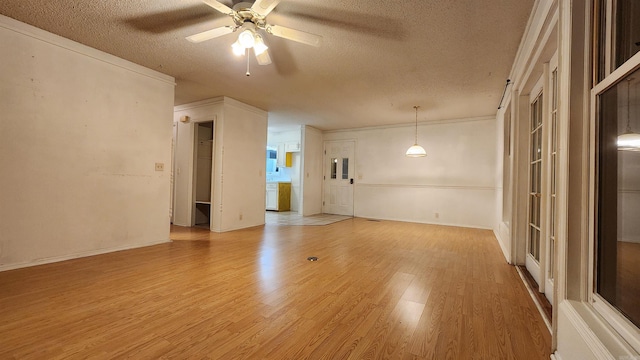 unfurnished room featuring ceiling fan, light hardwood / wood-style floors, a textured ceiling, and ornamental molding