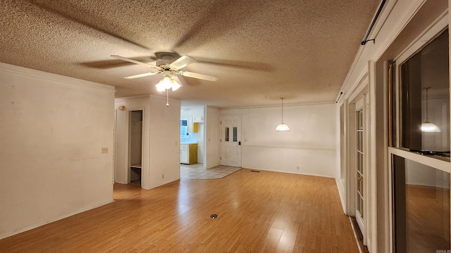 unfurnished room featuring a textured ceiling, light hardwood / wood-style floors, ceiling fan, and ornamental molding