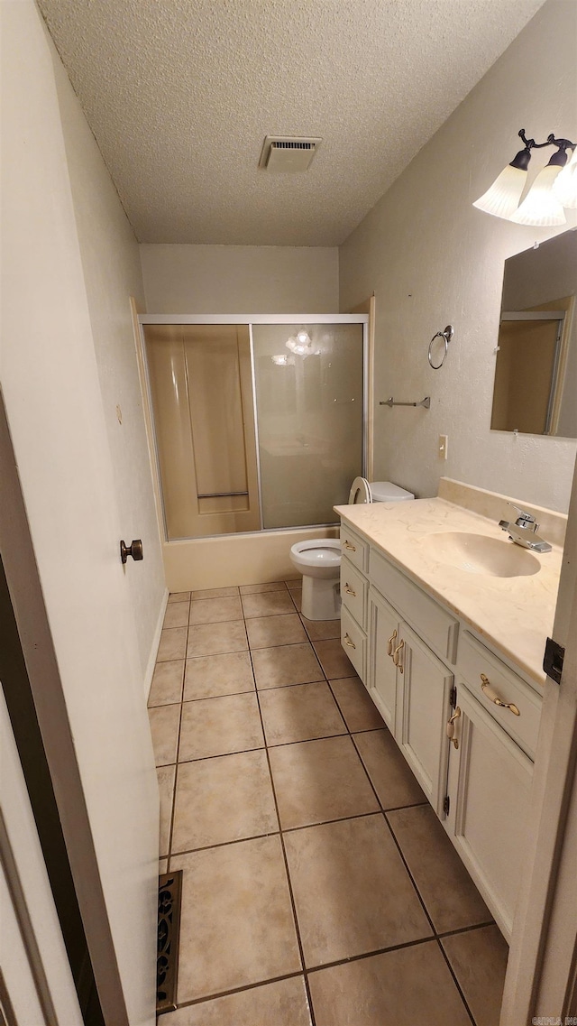 full bathroom with vanity, tile patterned flooring, toilet, enclosed tub / shower combo, and a textured ceiling