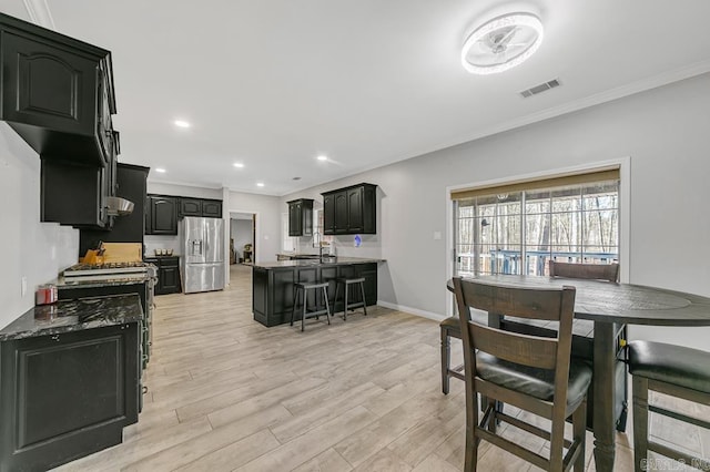 dining space with crown molding and light hardwood / wood-style floors