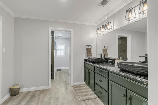 bathroom with crown molding, hardwood / wood-style floors, and vanity