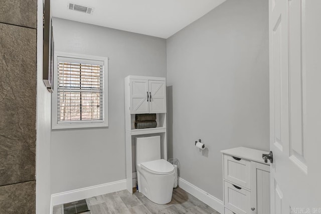 bathroom with hardwood / wood-style flooring and toilet