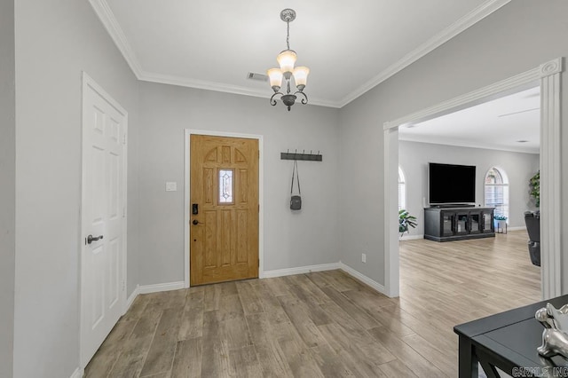 entrance foyer with light hardwood / wood-style floors, crown molding, and an inviting chandelier