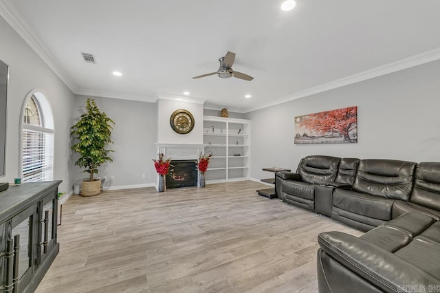 living room featuring built in shelves, ceiling fan, light hardwood / wood-style floors, and ornamental molding