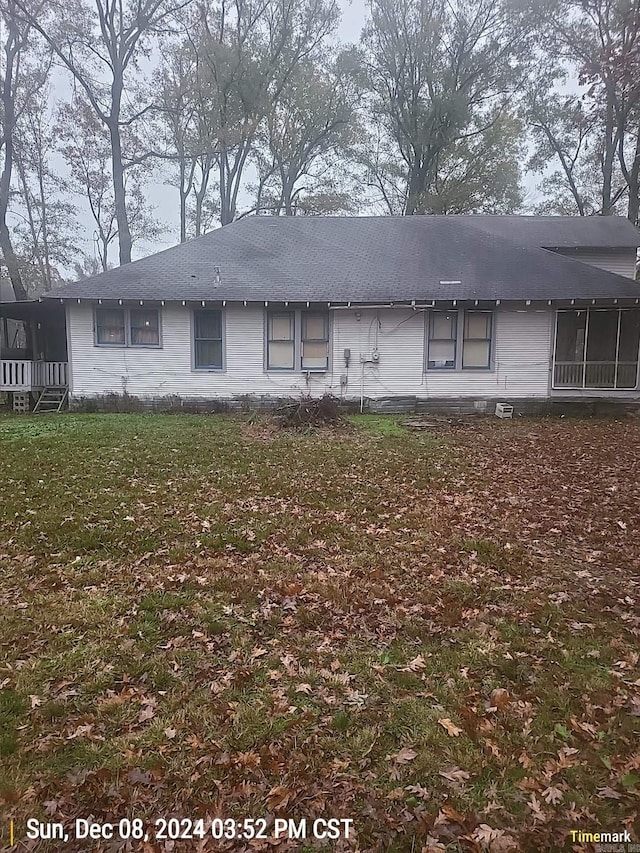 rear view of house featuring a lawn