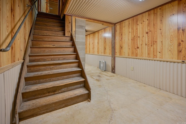 staircase featuring wooden walls