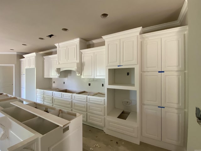 kitchen with white cabinetry, crown molding, recessed lighting, and under cabinet range hood