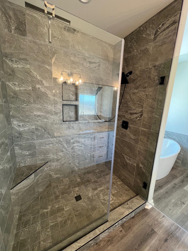 bathroom featuring hardwood / wood-style floors and plus walk in shower