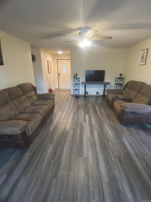 living room featuring a textured ceiling, dark hardwood / wood-style floors, and ceiling fan