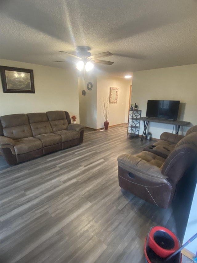 living room with a textured ceiling, hardwood / wood-style flooring, and ceiling fan