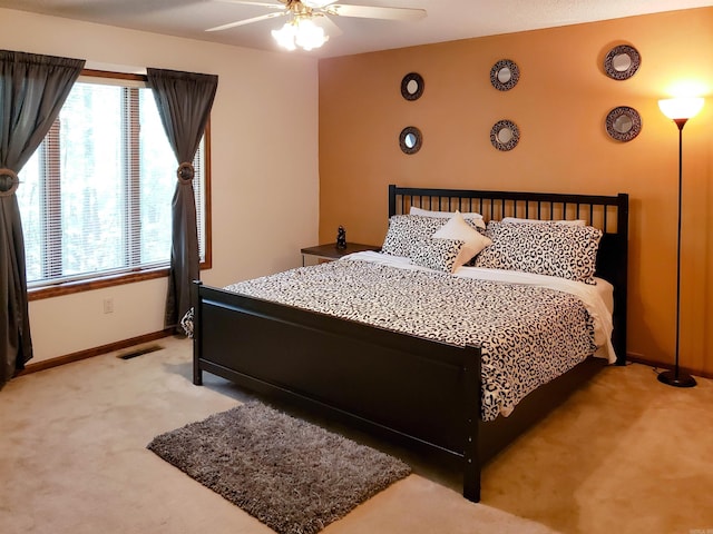 carpeted bedroom with multiple windows and ceiling fan