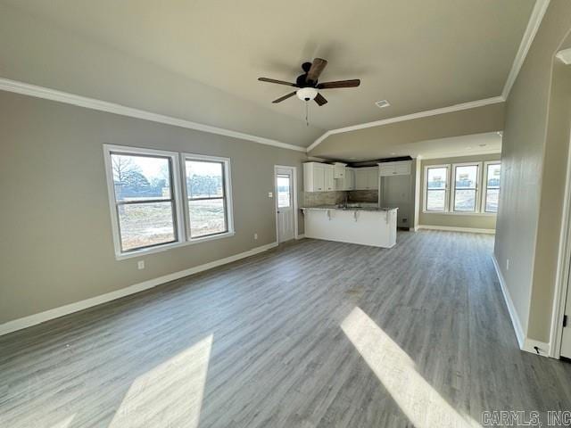 unfurnished living room with light hardwood / wood-style floors, vaulted ceiling, ceiling fan, and crown molding