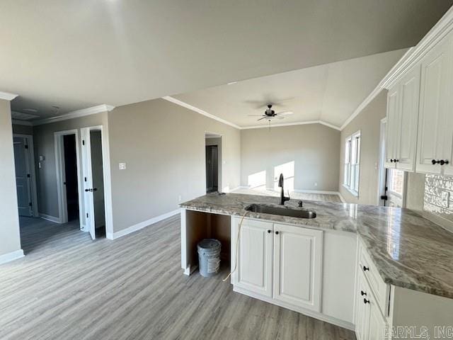 kitchen featuring ceiling fan, sink, light stone countertops, white cabinets, and ornamental molding