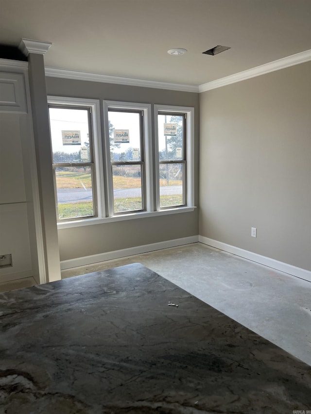 unfurnished room featuring concrete flooring, crown molding, and a healthy amount of sunlight