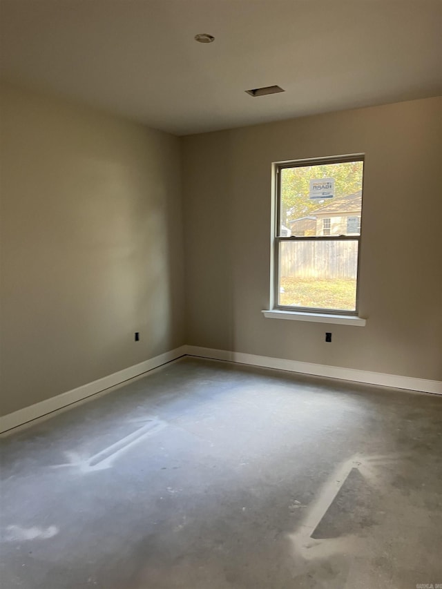 unfurnished room with concrete flooring