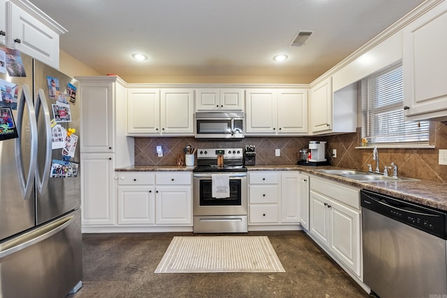 kitchen featuring appliances with stainless steel finishes, tasteful backsplash, white cabinetry, and sink